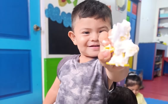 Niño de 1 año explorando materiales sensoriales en colegio maternal